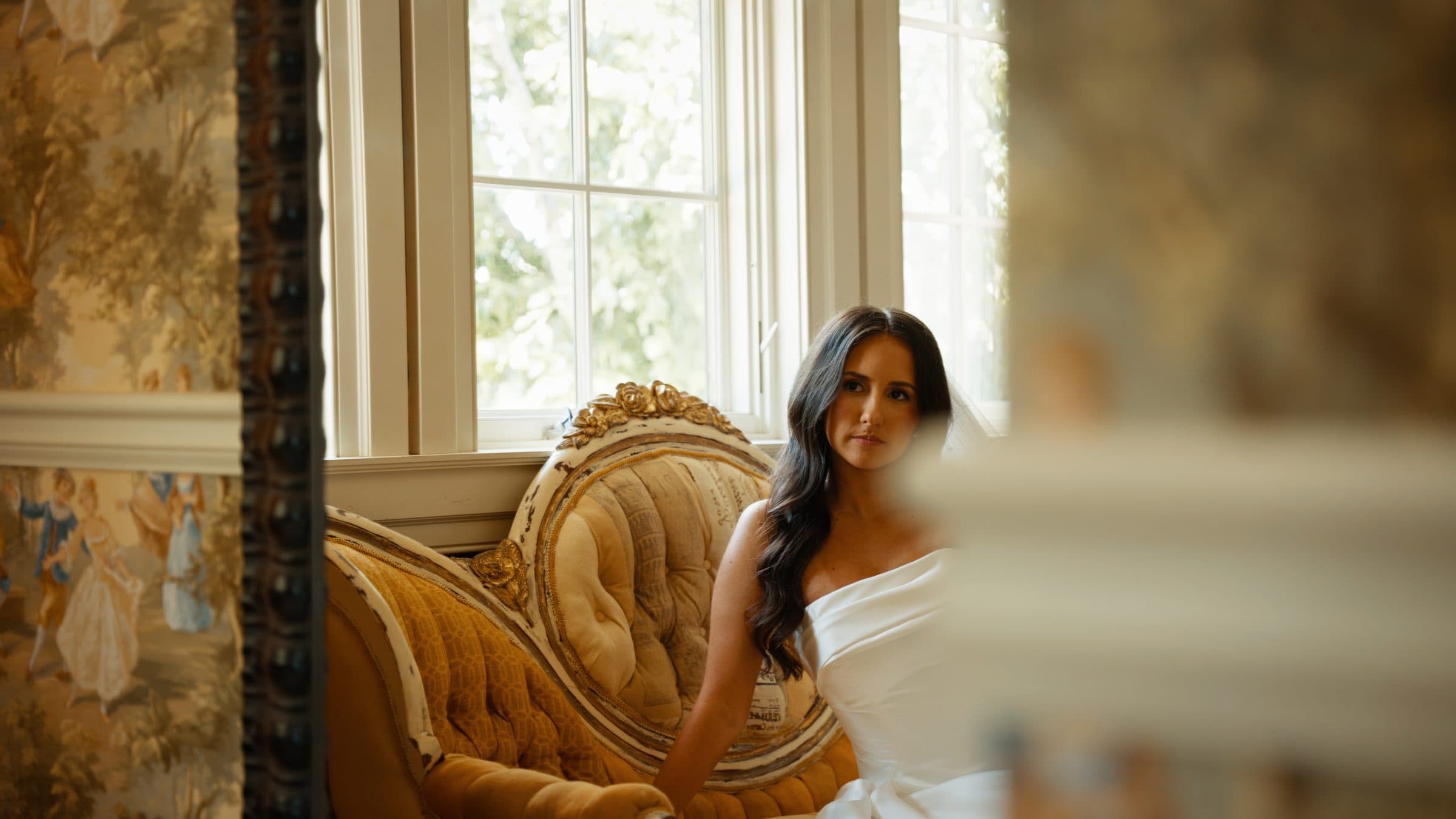 A bride in the morning light by the window, before the ceremony